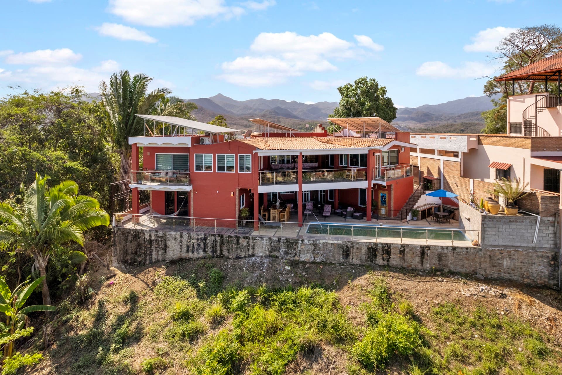 Wide aerial shot showing ocean and mountain dual views